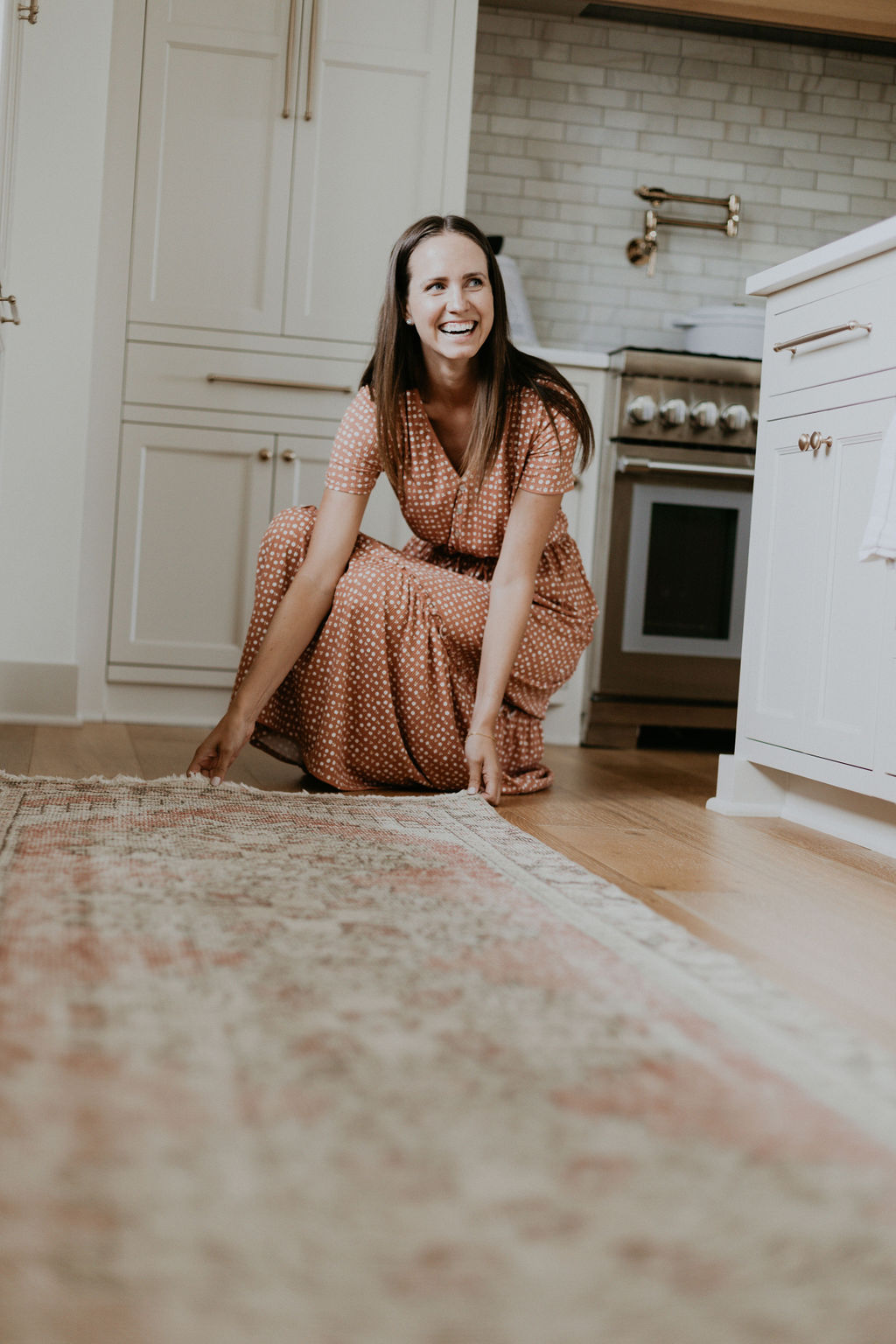 Woman setting down runner rug in kitchen